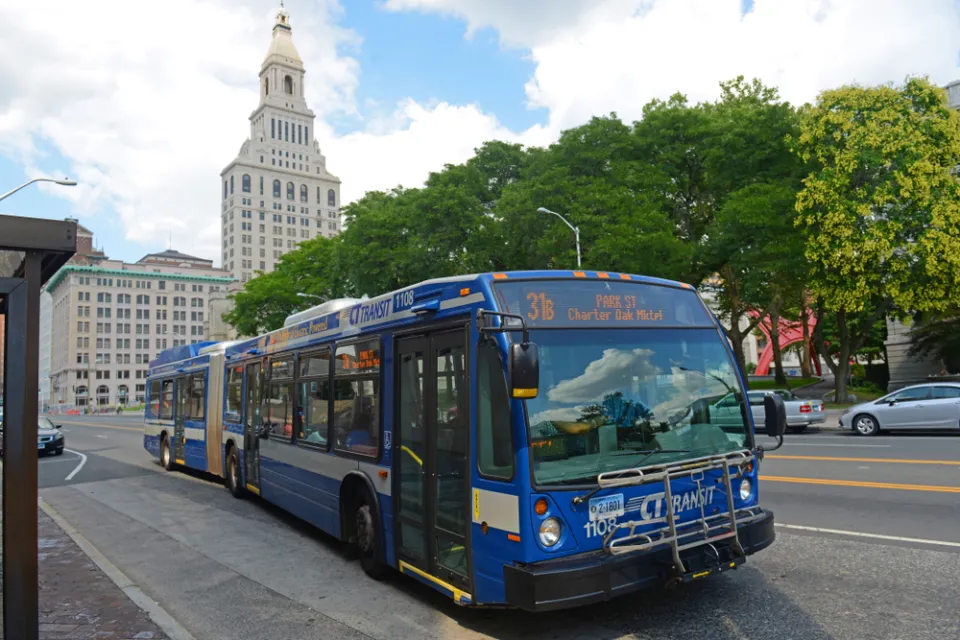 Blue CT Transit bus in Hartford, Connecticut with state capitol building in background
